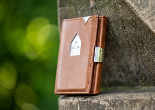 Exentri plånbok i brunt läder på trä 