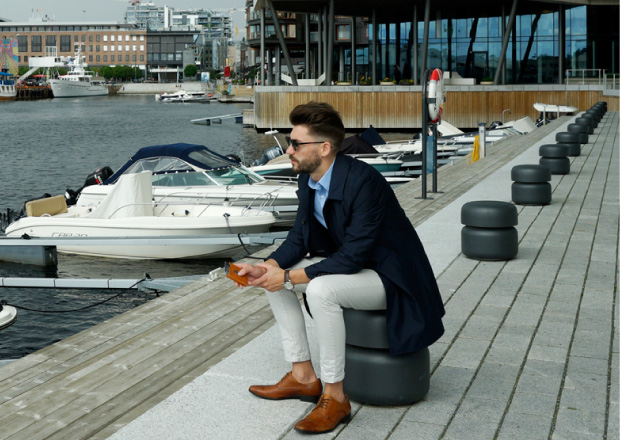 Man sitting by the sea holding a Exentri wallet